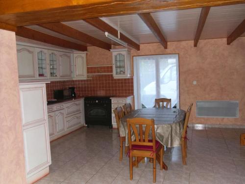 une cuisine avec une table et des chaises dans une pièce dans l'établissement maison yvonne, à Plouha