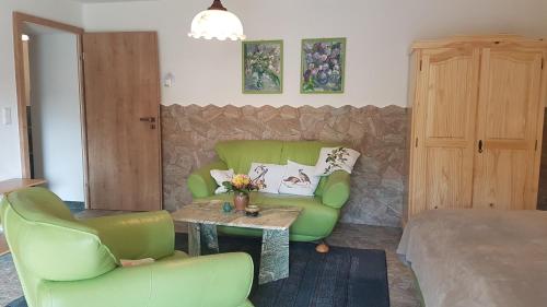 a living room with a green couch and a table at Pension Tannenspitze in Lutherstadt Wittenberg