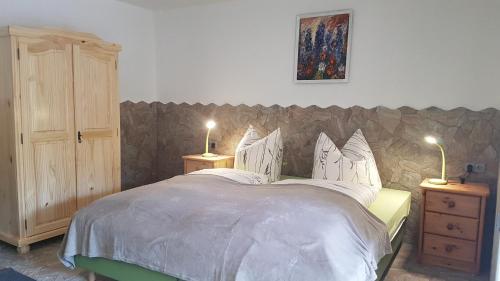 a bedroom with a large bed with two night stands at Hotel Tannenspitze in Lutherstadt Wittenberg