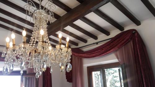 a dining room with a chandelier and a window at B&B L'Orologio in Signa