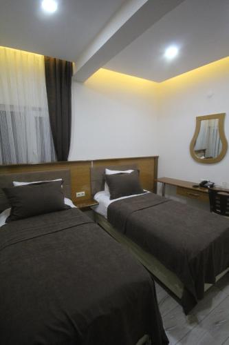 a hotel room with two beds and a mirror at Gulistan Hotel in Zara