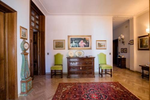 a living room with two chairs and a dresser at villa oliveta in San Gimignano