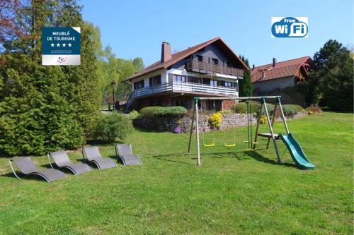 a yard with a playground with chairs and a house at Chalet Beau Regard in Hellert