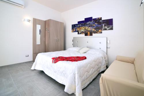 a bedroom with a white bed with a red dress on it at The Stunning B&B in Peschici
