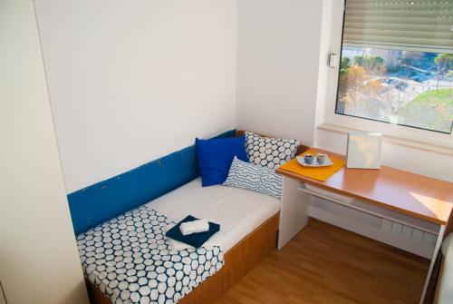 a small bed with a desk in a room at Split Summer Budget Rooms in Split