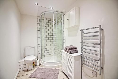 a white bathroom with a shower and a toilet at Star Apartment Ipswich, A Hidden Gem near the Waterfront in Ipswich