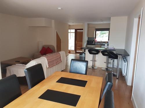 a living room with a wooden table and a kitchen at 6 the courtyard, Mulranny in Mulranny