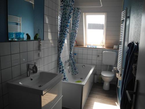 y baño con bañera, lavabo y aseo. en Ferienwohnung Spatzennest en Wesel