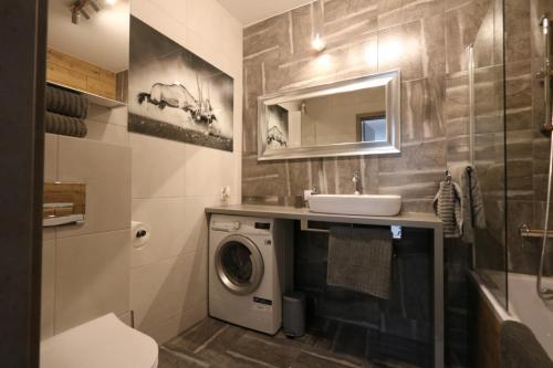 a bathroom with a washing machine and a sink at Blue - Bastion Wałowa in Gdańsk