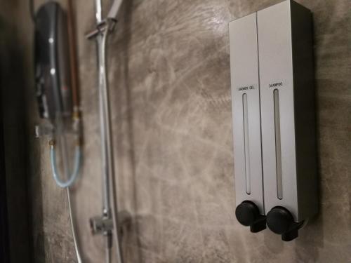 a soap dispenser on the wall of a shower at The Rise Room in Kuala Terengganu