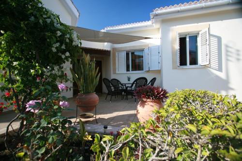 a patio of a house with flowers and plants at Beach Villa Sofia in Neo Chorio