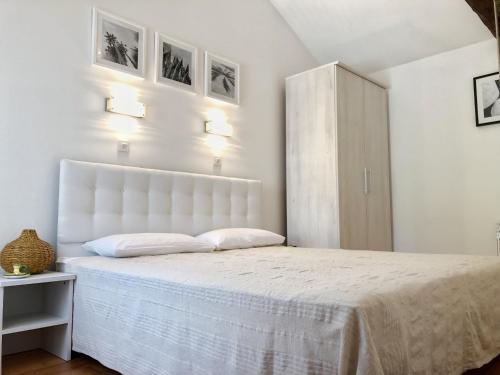 una camera bianca con un grande letto con testiera bianca di LacoDeLama mini resort a Ližnjan (Lisignano)
