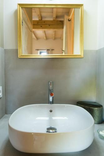 un lavabo blanc dans une salle de bain avec un miroir dans l'établissement Domaine de Gailhaguet B&B, à Verfeil