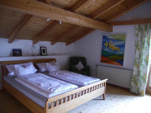 ein Schlafzimmer mit einem Holzbett in einem Zimmer in der Unterkunft Landhaus Bernecker, Bay.W. in Rinchnach