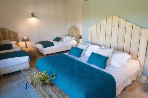 a bedroom with two beds with blue and white pillows at Domaine de Gailhaguet B&B in Verfeil