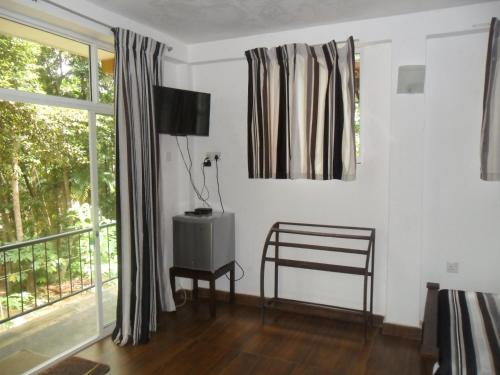 a living room with a chair and a window at river edge bungalow in Matale