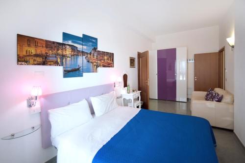 a bedroom with a blue and white bed and a couch at The Stunning B&B in Peschici