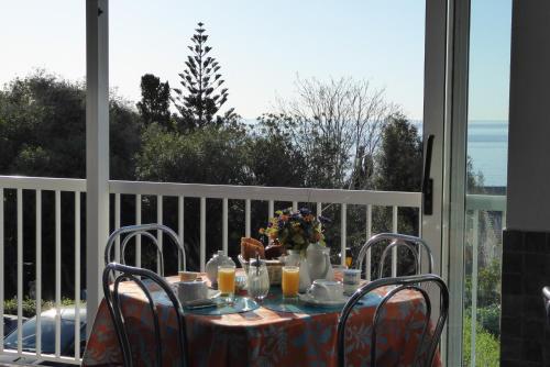 a table on a balcony with a table and chairs at Hotel Cyrnea in Bastia