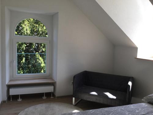 a bedroom with a couch and a window at Ferienwohnung Villa Josephine in Badenweiler
