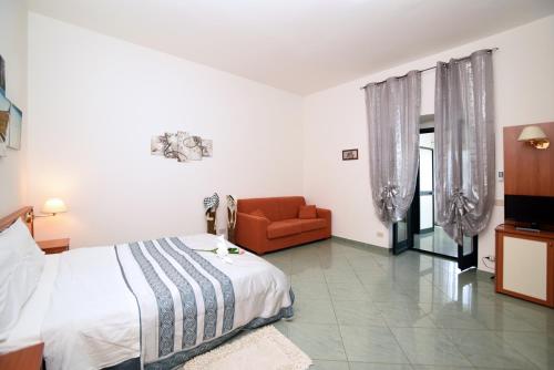 a bedroom with a bed and a couch in it at The Stunning B&B in Peschici