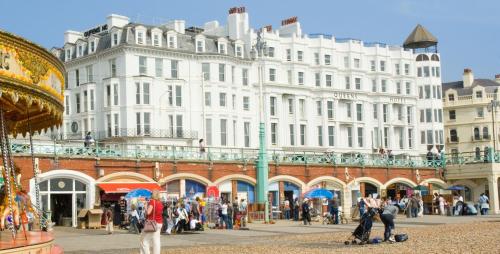 a large white building with people standing in front of it at Queens Hotel & Spa in Brighton & Hove