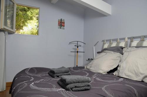 - une chambre avec un lit doté de couvertures et d'oreillers gris dans l'établissement Mas du Puech Cymbale, à Assas