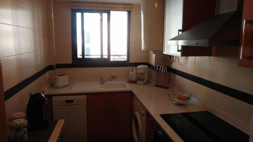 een kleine keuken met een wastafel en een raam bij Golf Panoramica in Sant Jordi