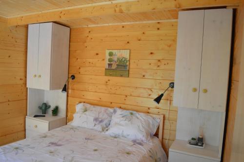 a bedroom with a wooden wall with a bed and cabinets at Bamboo Guest House in Águeda