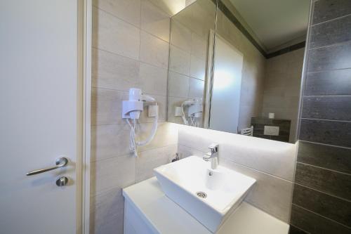 y baño con lavabo blanco y espejo. en Guesthouse & restaurant Tekovina, en Smederevo