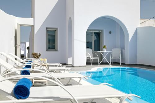 basen z krzesłami i stołem oraz basen w obiekcie Santorini Blue Senses Villas w mieście Mesaria