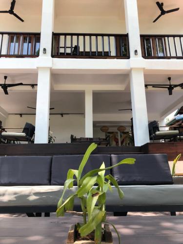a couch in front of a building with windows at Moonlight Champa Riverview in Luang Prabang