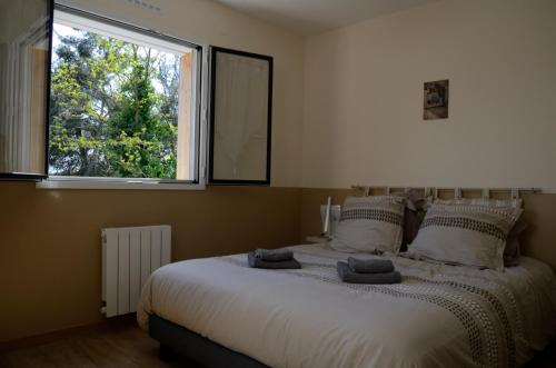 une chambre avec un grand lit avec une fenêtre dans l'établissement Le Mas du Puech Cigale, à Assas