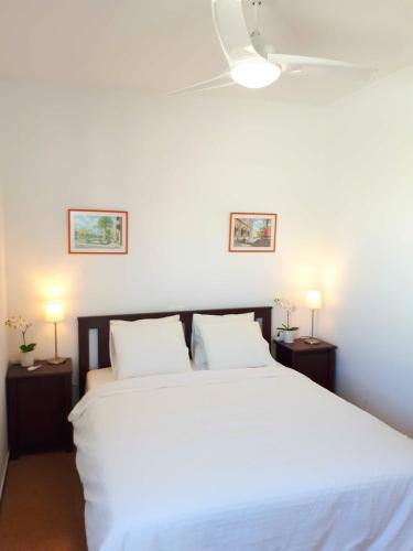 a bedroom with a large white bed with two lamps at City Beach Home 60 in Las Palmas de Gran Canaria