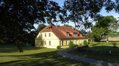duży żółty dom z czerwonym dachem w obiekcie Ferienhaus Gut Rattelvitz Insel Rügen w mieście Gingst