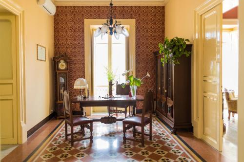 a dining room with a table and a window at Palazzo al Carmine Dimora Storica in Castelvetrano Selinunte