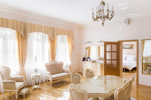 salon ze stołem, krzesłami i łóżkiem w obiekcie Aristocrat Boutique Hotel w Petersburgu