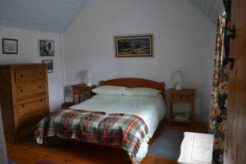 a bedroom with a bed and two night stands and a dresser at Marsh Cottage F91 N4A9 in Moneygold