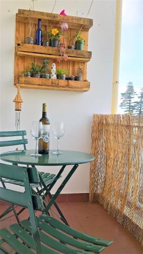 a table with two glasses and a bottle of wine at Praia Mar in Ribeira Grande