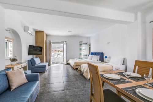 salon z 2 łóżkami i jadalnią w obiekcie Santorini Blue Senses Villas w mieście Mesaria