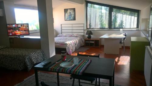 sala de estar con cama y mesa en una habitación en Villa Cardinal Apartments, en Tívoli