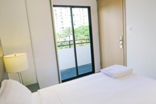 a bedroom with a white bed and a large window at Comfy Studio 4 by ReCharge in Singapore