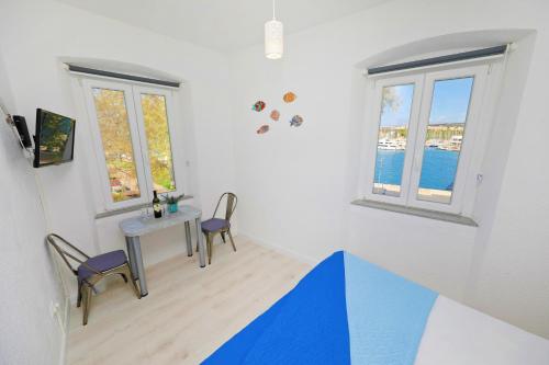 a room with two windows and a table and chairs at Sea View Studio Apartment in Zadar