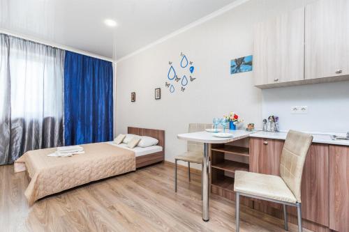 a bedroom with a bed and a table in a room at Апартаменты Central Park на Таврической 9к1 in Tyumen