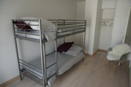 een slaapkamer met een stapelbed en een stoel bij Appartement Forum Reims in Reims