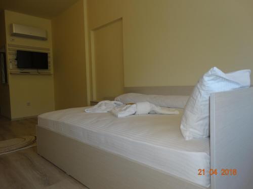 a bedroom with a bed with white sheets and pillows at Hotel Lago Peshtera in Peshtera