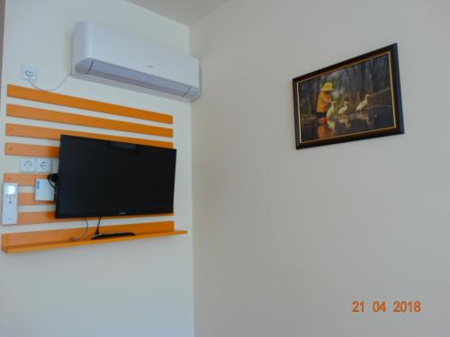 a living room with a flat screen tv on a wall at Hotel Lago Peshtera in Peshtera