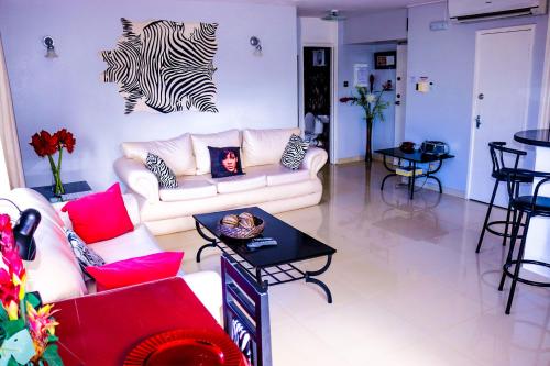 een woonkamer met een witte bank en zebrastickers aan de muur bij Surf Turf Two Bedroom Suite At Turtle Towers in Ocho Rios