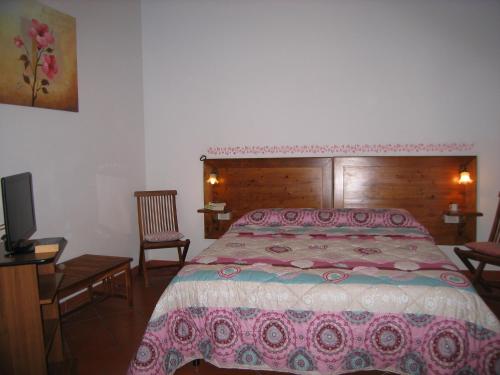 a bedroom with a bed and a tv in it at Borgo Sicelle Residence in San Donato in Poggio