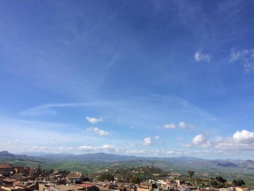 a view of a city with a blue sky and mountains at B&B Bella Vista in Valguarnera Caropepe