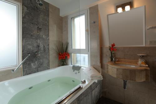 a bathroom with a large tub and a sink at Europlaza Hotel & Suites in Buenos Aires